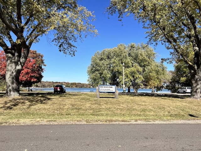 view of community featuring a water view and a lawn