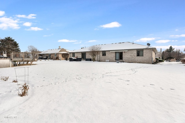 view of snow covered back of property