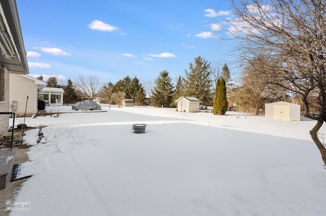 yard covered in snow with a storage shed