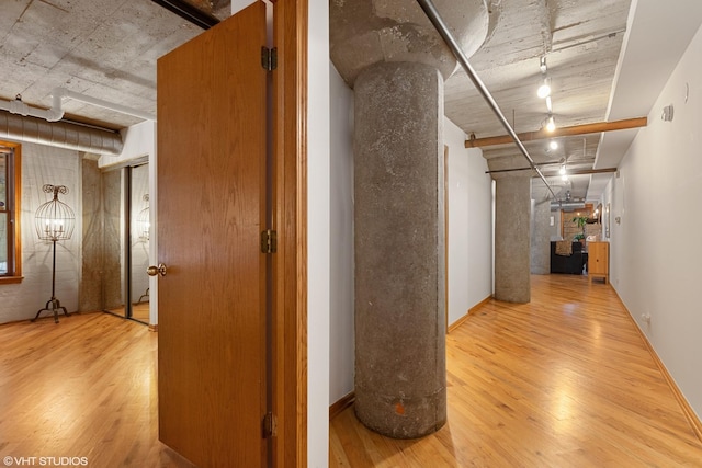 corridor featuring wood finished floors and track lighting