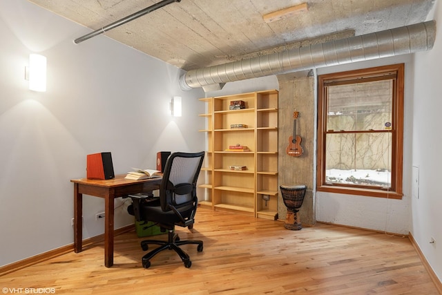 office space with light wood-type flooring and baseboards