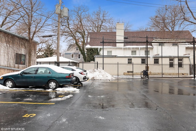 uncovered parking lot featuring fence