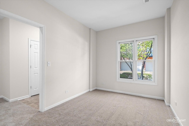 spare room featuring light colored carpet