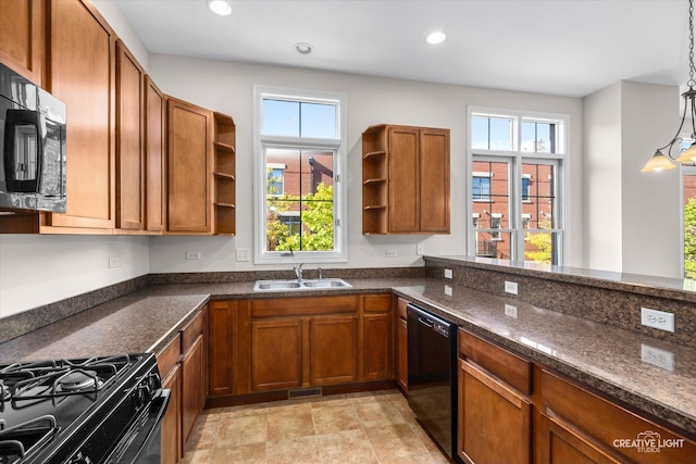 kitchen with sink, pendant lighting, dark stone counters, and black appliances