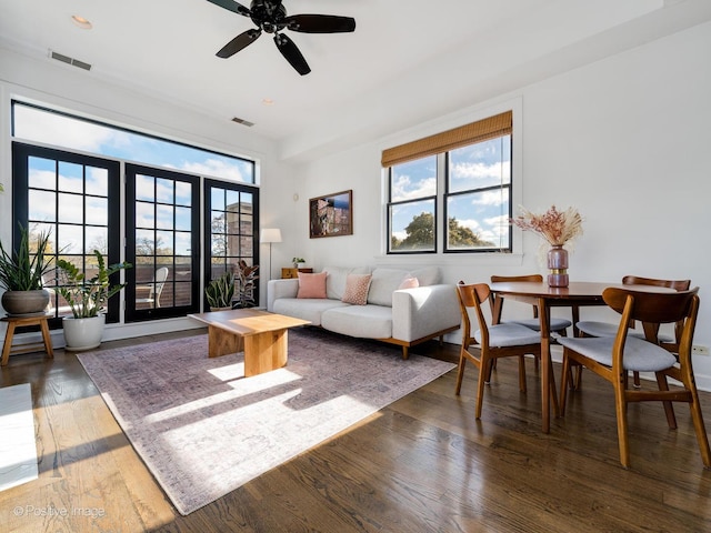 living room with ceiling fan, dark wood-type flooring, and a wealth of natural light