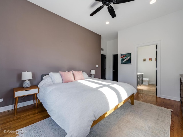 bedroom featuring ceiling fan, ensuite bath, and dark hardwood / wood-style floors