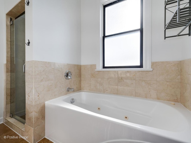 bathroom featuring tile walls and independent shower and bath