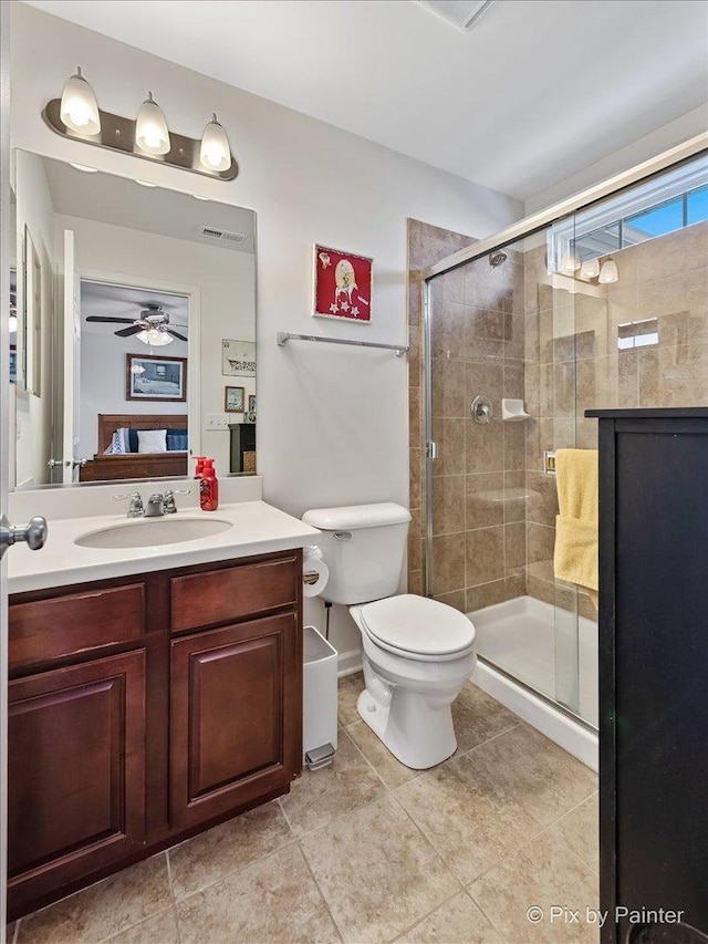 bathroom featuring ceiling fan, a shower with door, vanity, and toilet