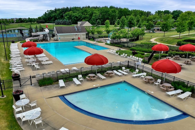 view of pool featuring a water slide and a patio area