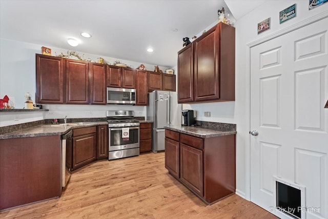 kitchen featuring appliances with stainless steel finishes, light hardwood / wood-style flooring, and sink