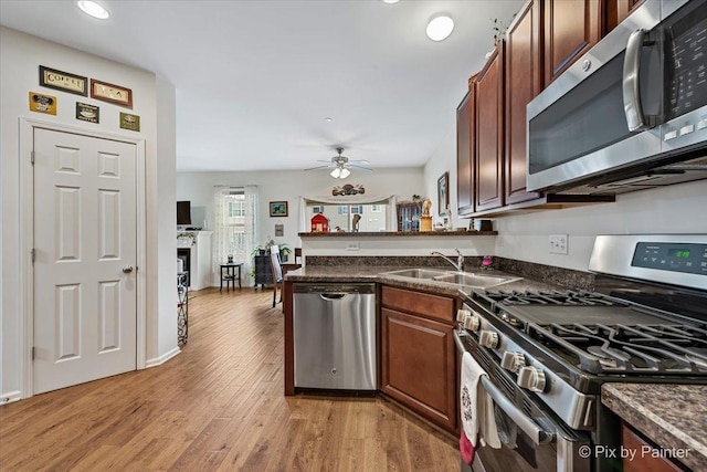 kitchen with kitchen peninsula, light hardwood / wood-style flooring, appliances with stainless steel finishes, ceiling fan, and sink