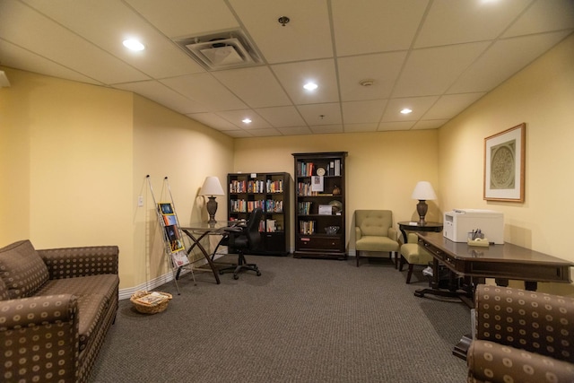 office area with a paneled ceiling and dark colored carpet