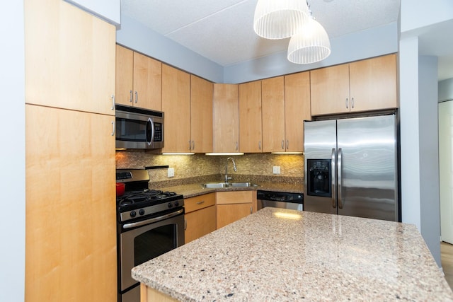 kitchen with sink, hanging light fixtures, stainless steel appliances, decorative backsplash, and light brown cabinets