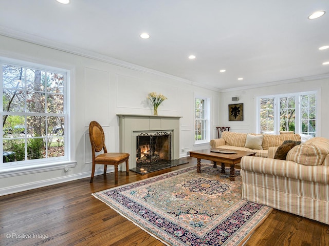 living room featuring crown molding, a healthy amount of sunlight, and dark hardwood / wood-style floors