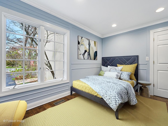 bedroom featuring crown molding and dark hardwood / wood-style floors