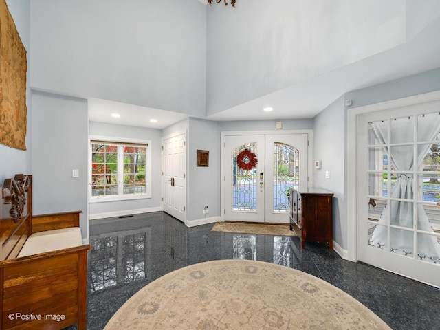 entryway featuring a towering ceiling and french doors