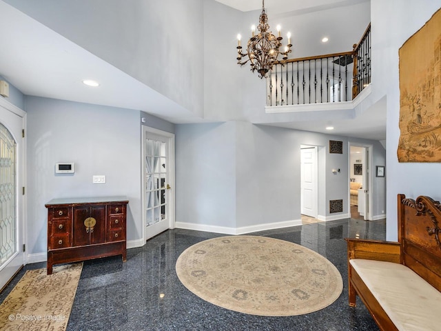 foyer featuring a towering ceiling and a chandelier