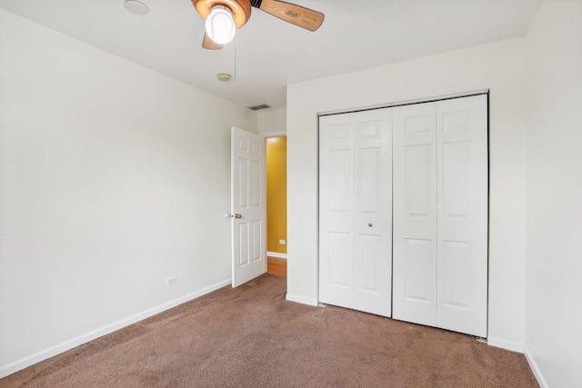 unfurnished bedroom featuring ceiling fan, a closet, and carpet flooring