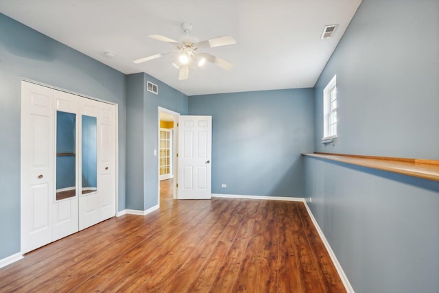 unfurnished bedroom with wood-type flooring, a closet, and ceiling fan