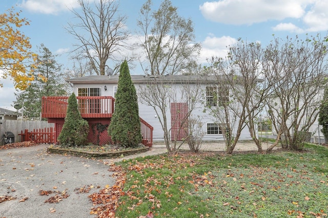 rear view of property featuring a wooden deck