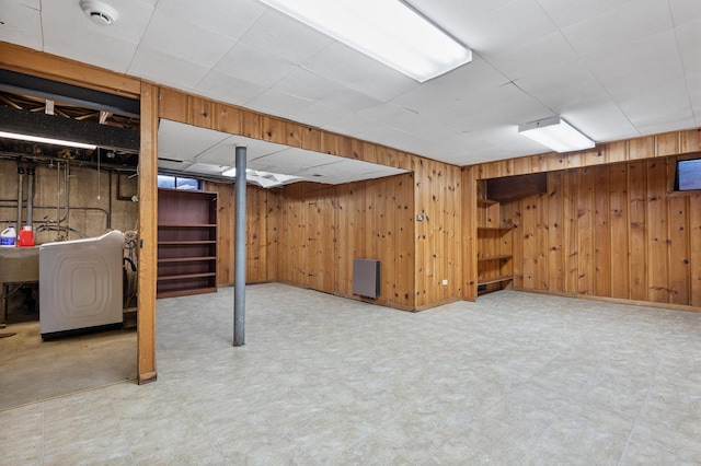 basement with wood walls and washer / dryer