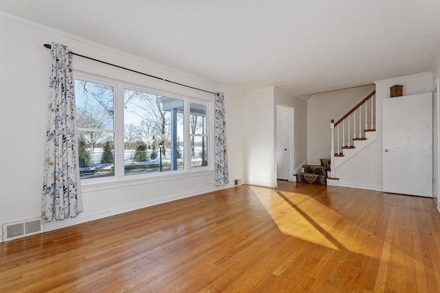 unfurnished living room featuring crown molding and hardwood / wood-style flooring