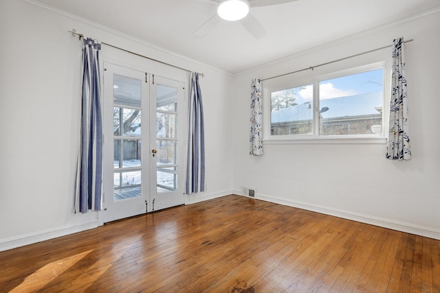 spare room with ceiling fan, french doors, crown molding, and hardwood / wood-style flooring