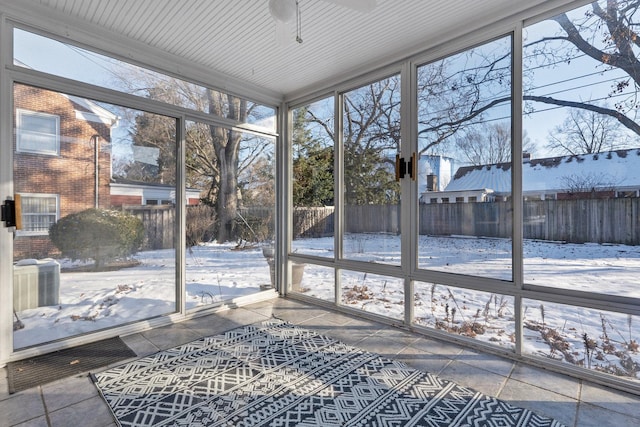 unfurnished sunroom with ceiling fan and a healthy amount of sunlight