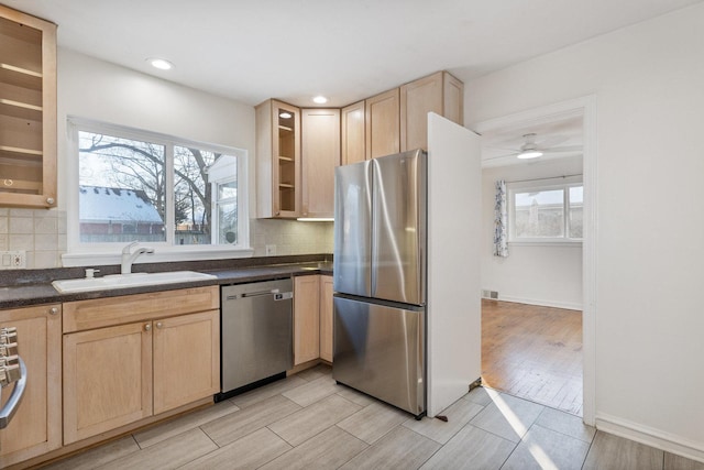 kitchen with ceiling fan, appliances with stainless steel finishes, light brown cabinets, tasteful backsplash, and sink