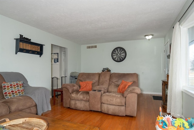 living room featuring light hardwood / wood-style flooring and a textured ceiling