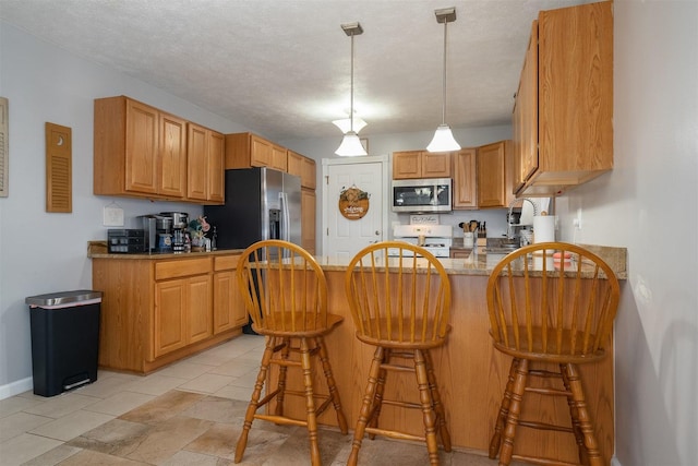 kitchen with stone counters, a textured ceiling, decorative light fixtures, kitchen peninsula, and stainless steel appliances