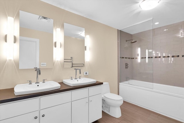 full bathroom with vanity, tiled shower / bath combo, and toilet