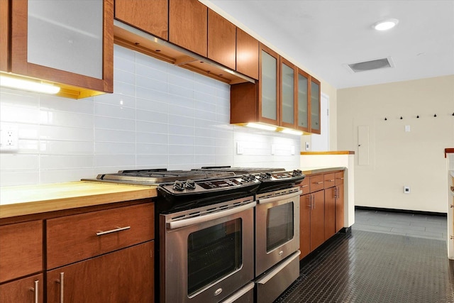 301 N Neil St Unit 808-809, Champaign, IL 61820 - kitchen featuring stainless steel gas range oven, decorative backsplash, glass insert cabinets, and brown cabinets