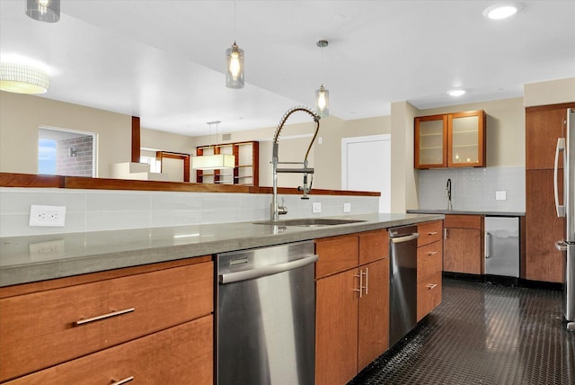 kitchen with sink, tasteful backsplash, light stone counters, hanging light fixtures, and appliances with stainless steel finishes