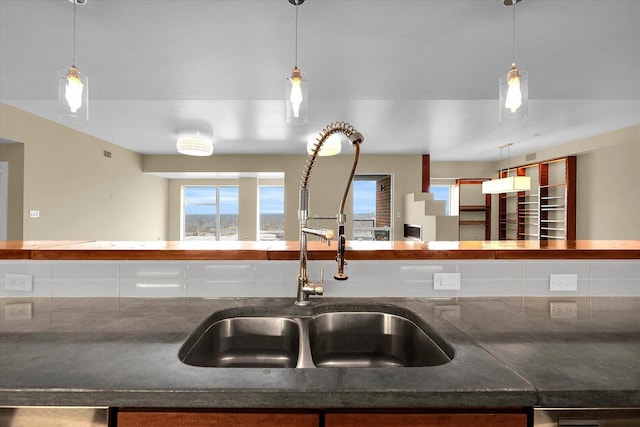 kitchen with sink, decorative light fixtures, and decorative backsplash