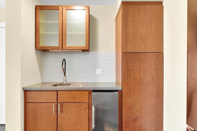 kitchen featuring tasteful backsplash, sink, and stainless steel fridge