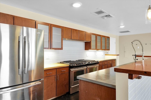 kitchen with pendant lighting, tasteful backsplash, and appliances with stainless steel finishes