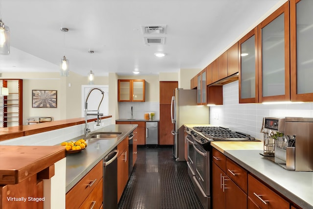 kitchen with hanging light fixtures, backsplash, sink, and appliances with stainless steel finishes