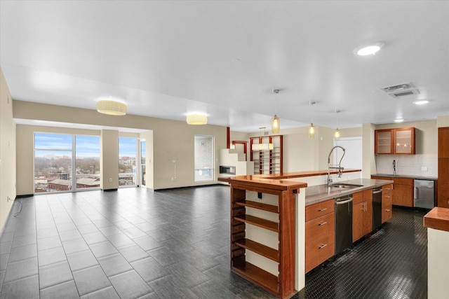 kitchen featuring sink, backsplash, and decorative light fixtures