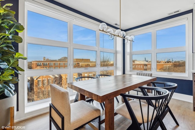 sunroom / solarium featuring a notable chandelier