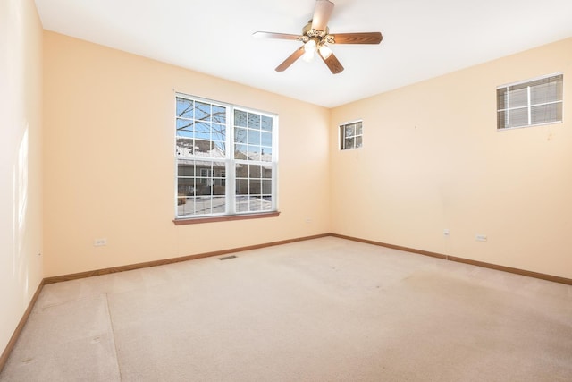 empty room featuring ceiling fan and light colored carpet