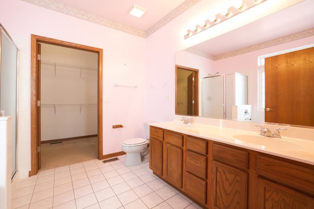 bathroom featuring vanity, toilet, tile patterned flooring, and an enclosed shower