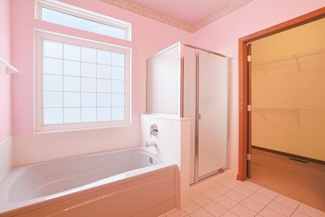 bathroom featuring shower with separate bathtub, a wealth of natural light, and tile patterned flooring