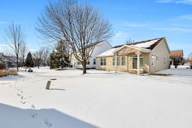 view of snow covered rear of property