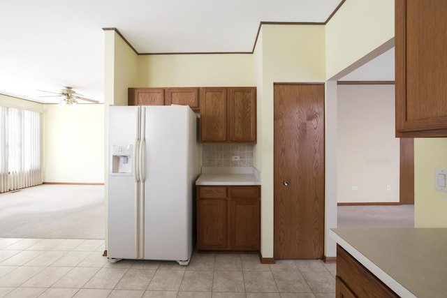 kitchen with ceiling fan, white refrigerator with ice dispenser, light colored carpet, and backsplash