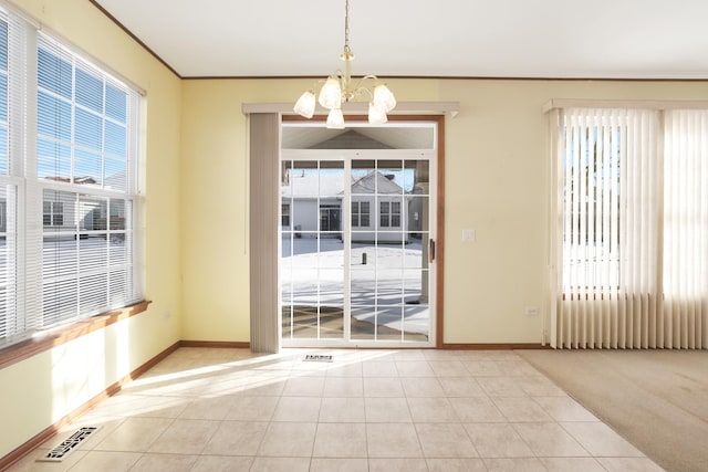 doorway with light tile patterned floors, crown molding, and a chandelier