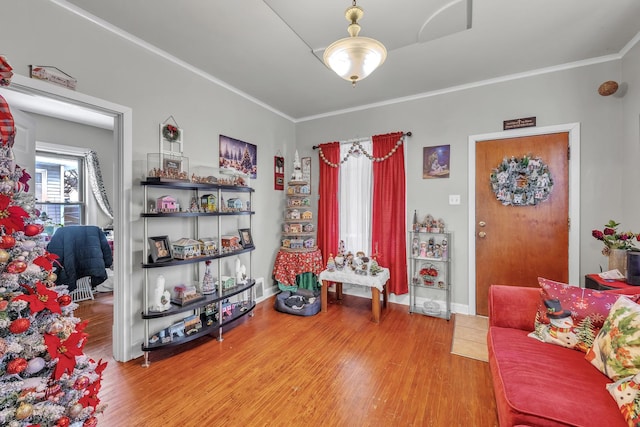 living area with ornamental molding and hardwood / wood-style floors