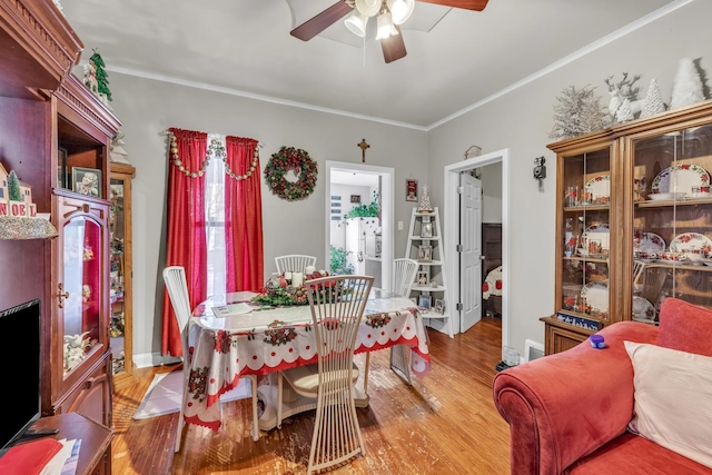 dining space featuring light wood-type flooring, ceiling fan, and crown molding