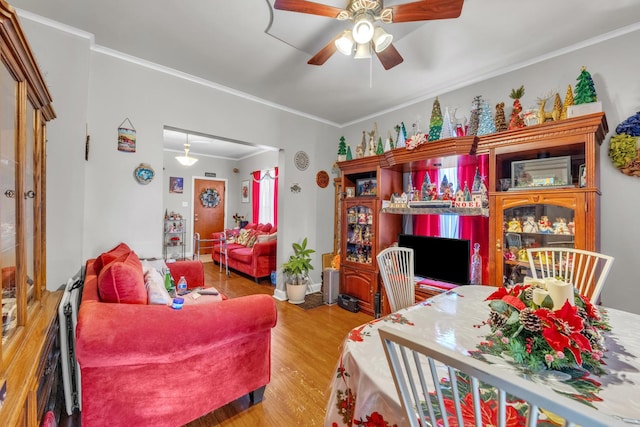 living room with ornamental molding, ceiling fan, and wood-type flooring