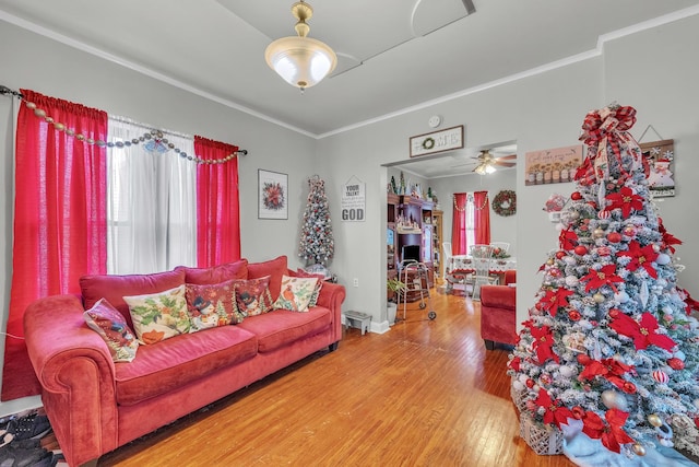 living room with ceiling fan, hardwood / wood-style floors, a wealth of natural light, and crown molding